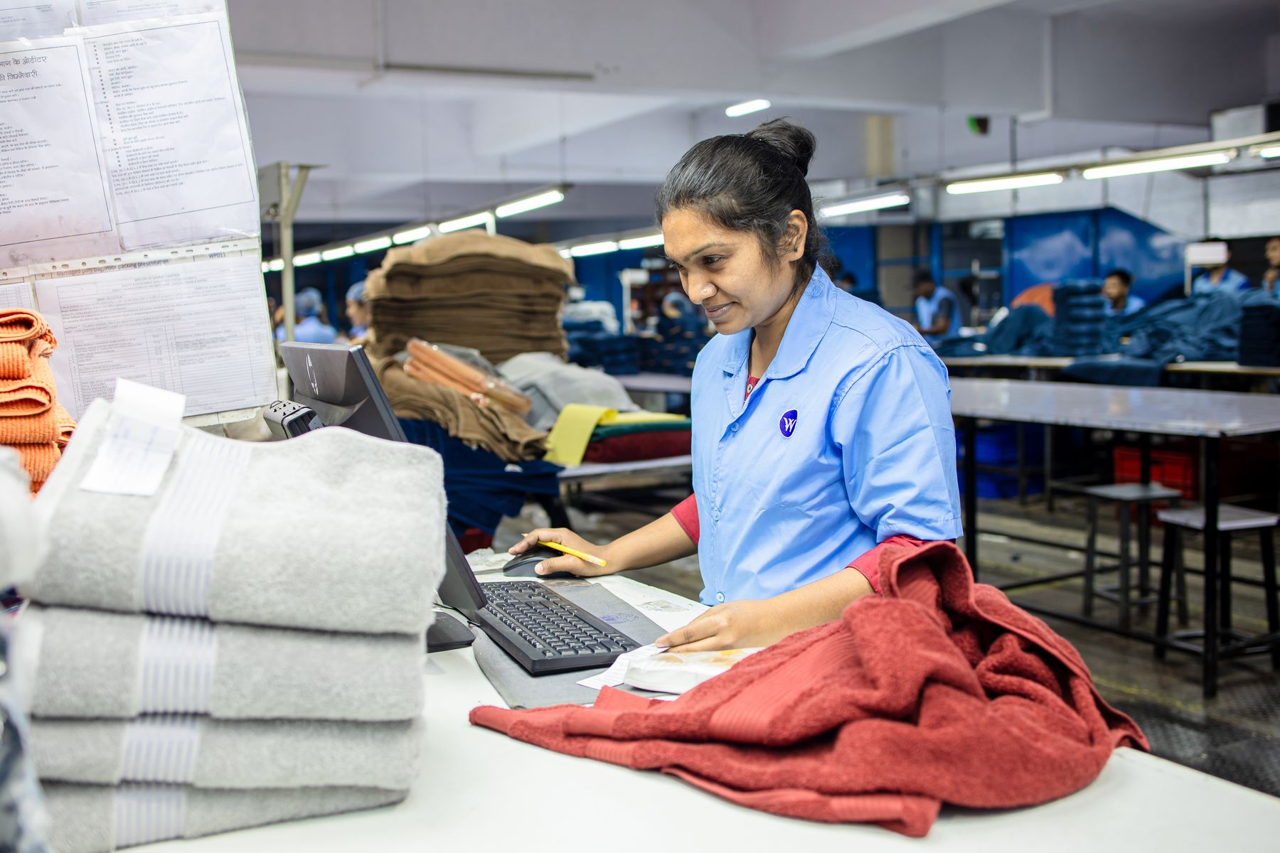 Worker checking and folding finished goods at a desk