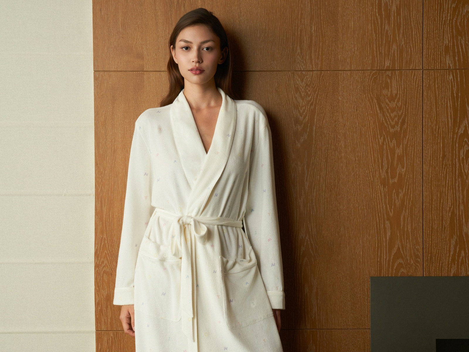 Woman wearing a white belted robe with a shawl collar